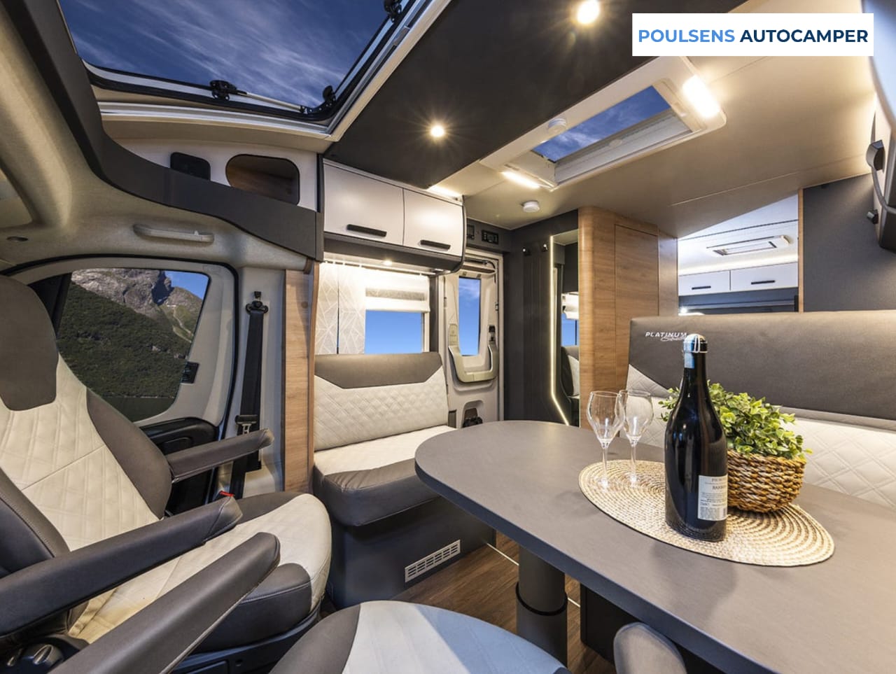Salon intérieur du camping-car semi-intégré Knaus LIVE TI 700 MEG Platinum Selection 2026 avec banquettes et table télescopique